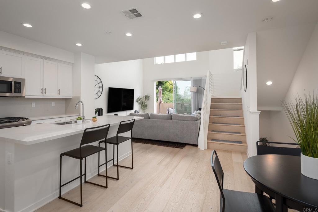 a kitchen with a table chairs refrigerator and microwave