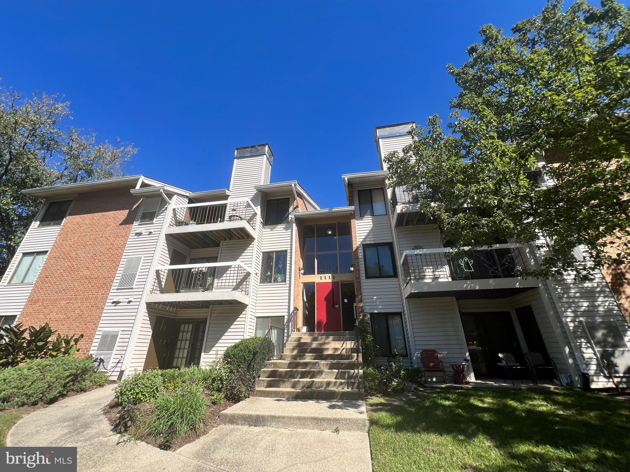 a front view of multi story residential apartment building with yard