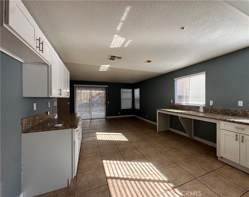 a kitchen with granite countertop a stove a sink and a microwave