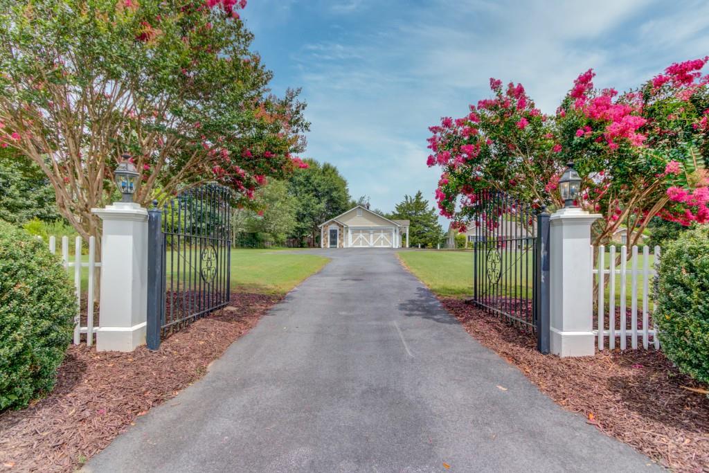 a view of a garden with flowers and wooden fence