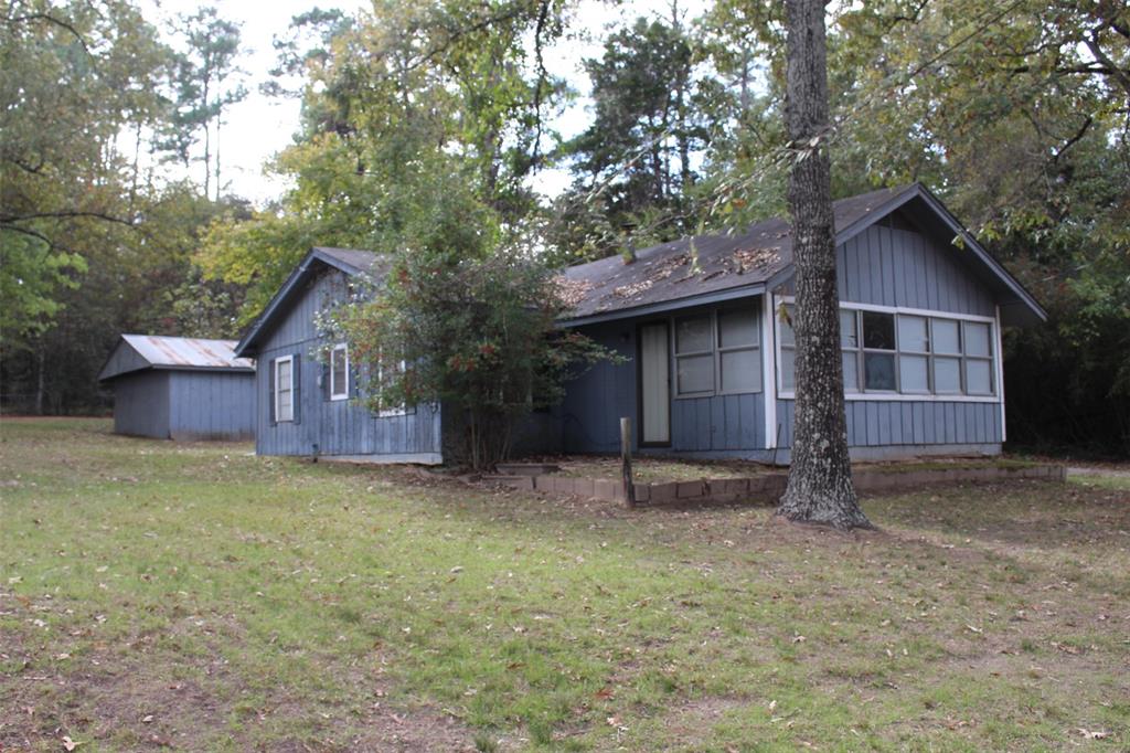 a view of a house with a yard and large tree