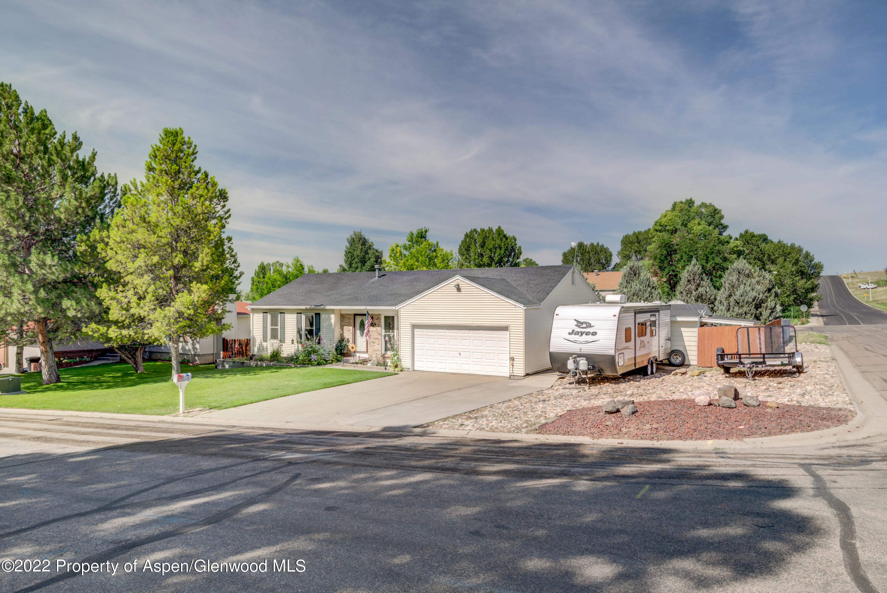 a front view of a house with a yard and trees