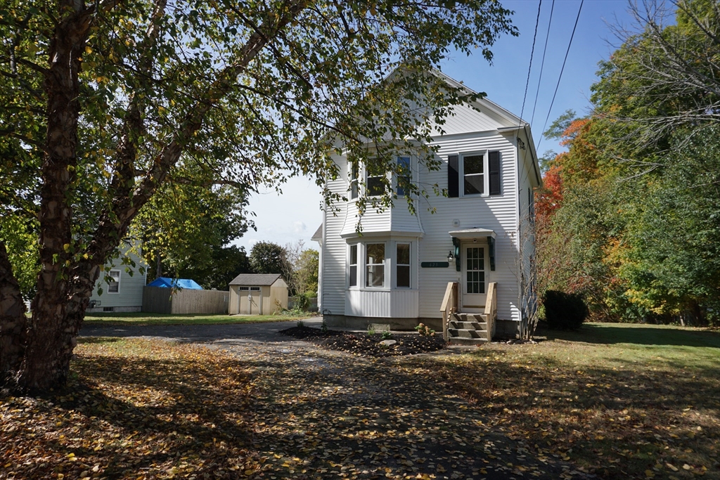 a front view of a house with a yard and trees