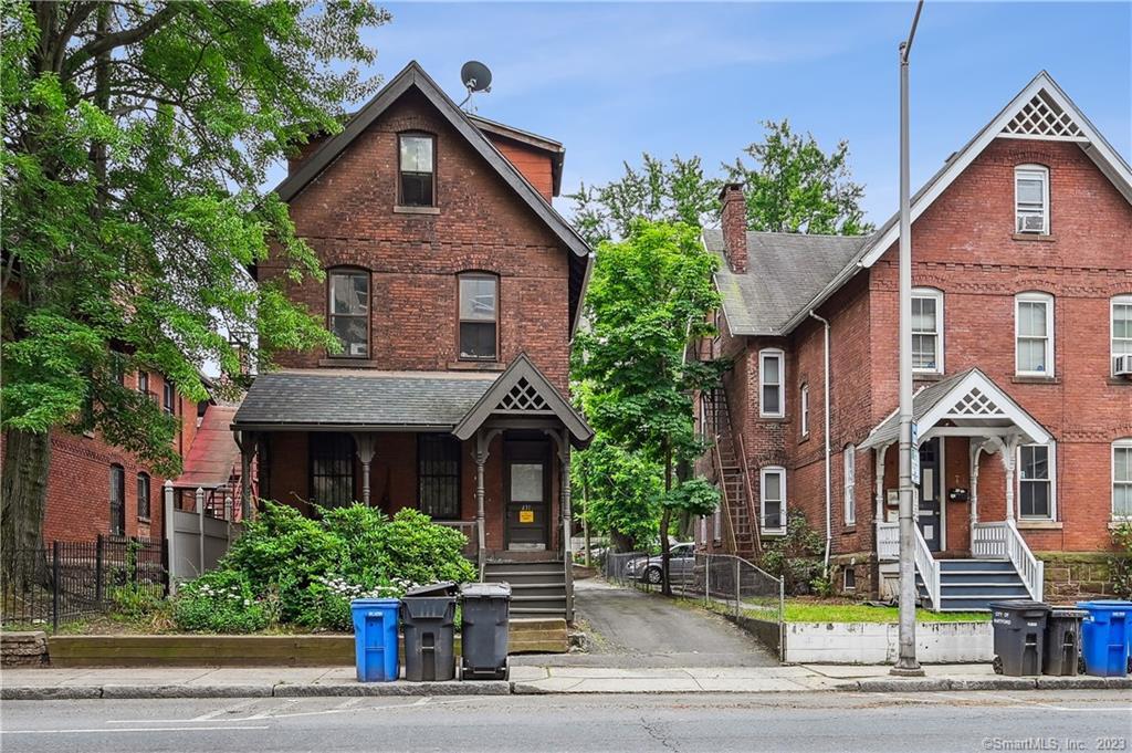 a front view of a house with a yard and potted plants