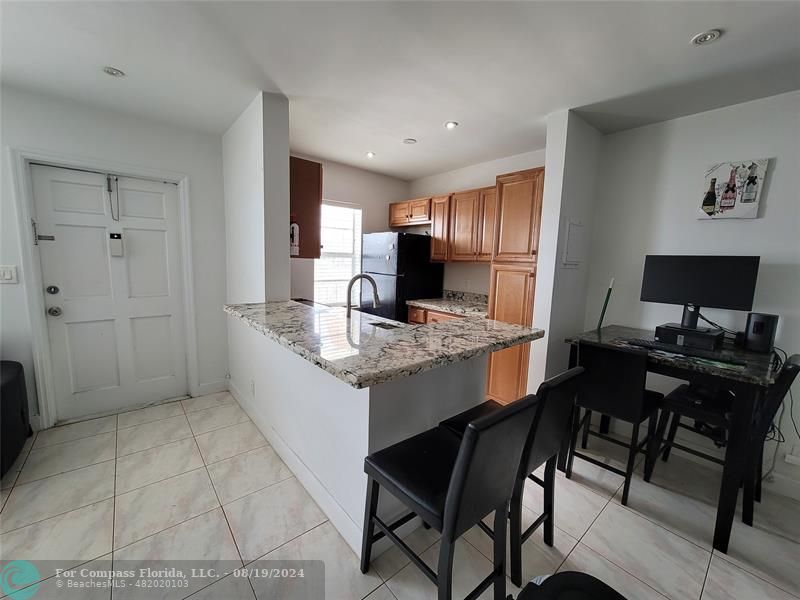 a kitchen with a table chairs and refrigerator