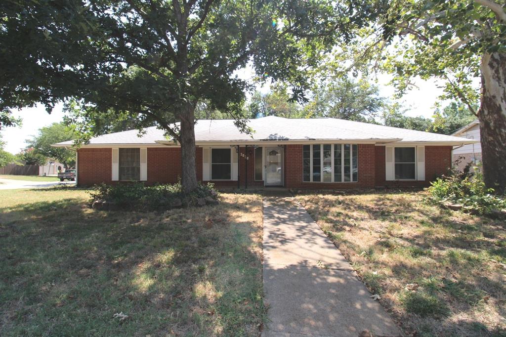 a view of a house with a tree in front of it