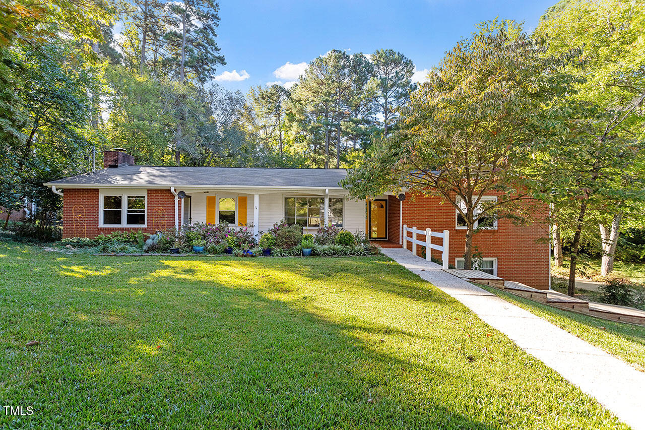 a view of a house with a big yard and large trees