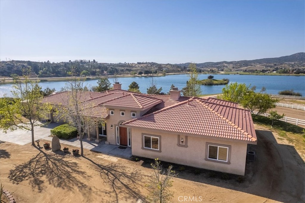 an aerial view of a house with a garden and lake view