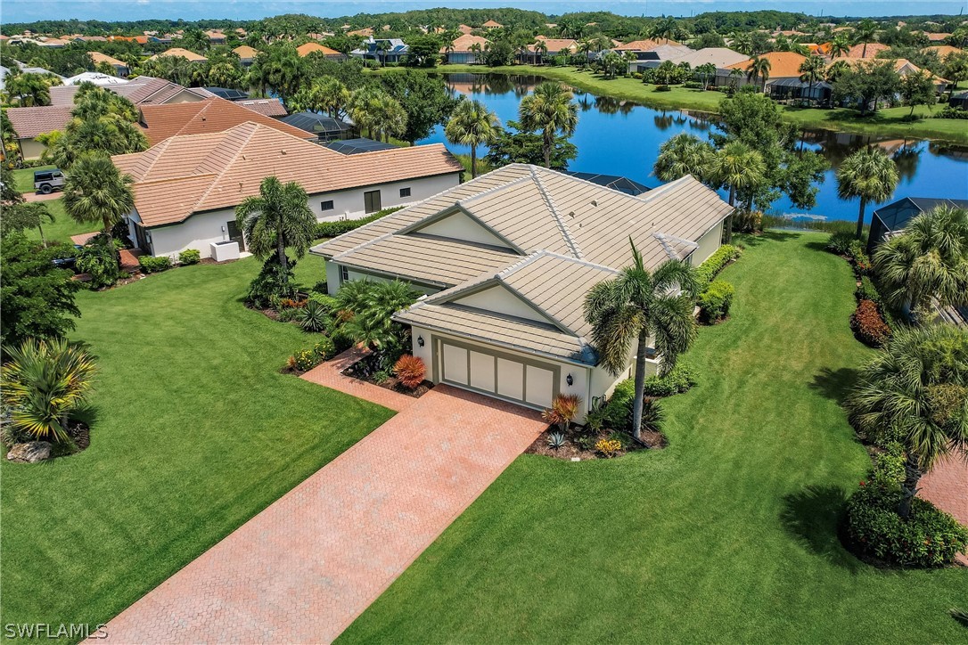 an aerial view of a house with a garden and lake view