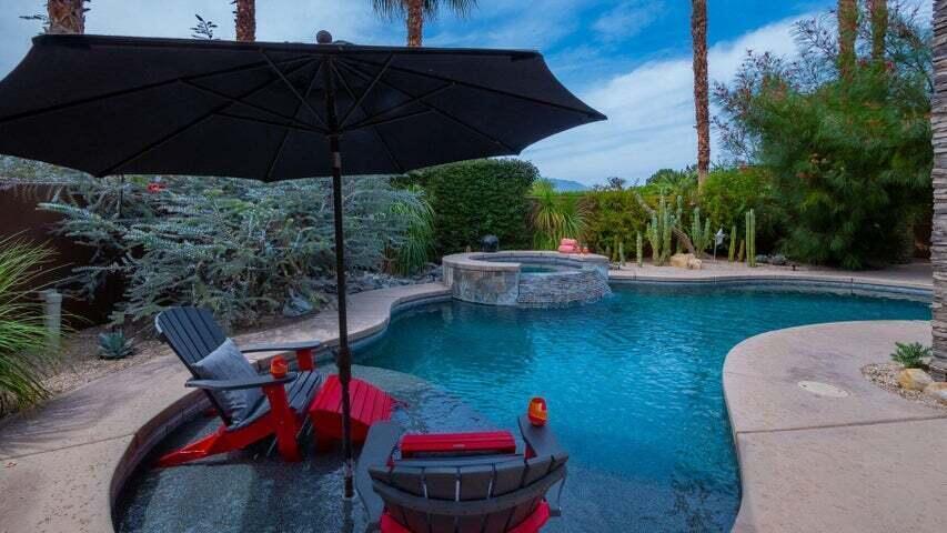 a view of a backyard with table and chairs under an umbrella