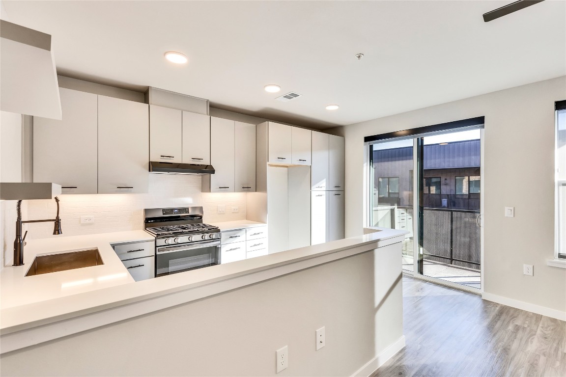 a kitchen with stainless steel appliances a stove a sink and a refrigerator