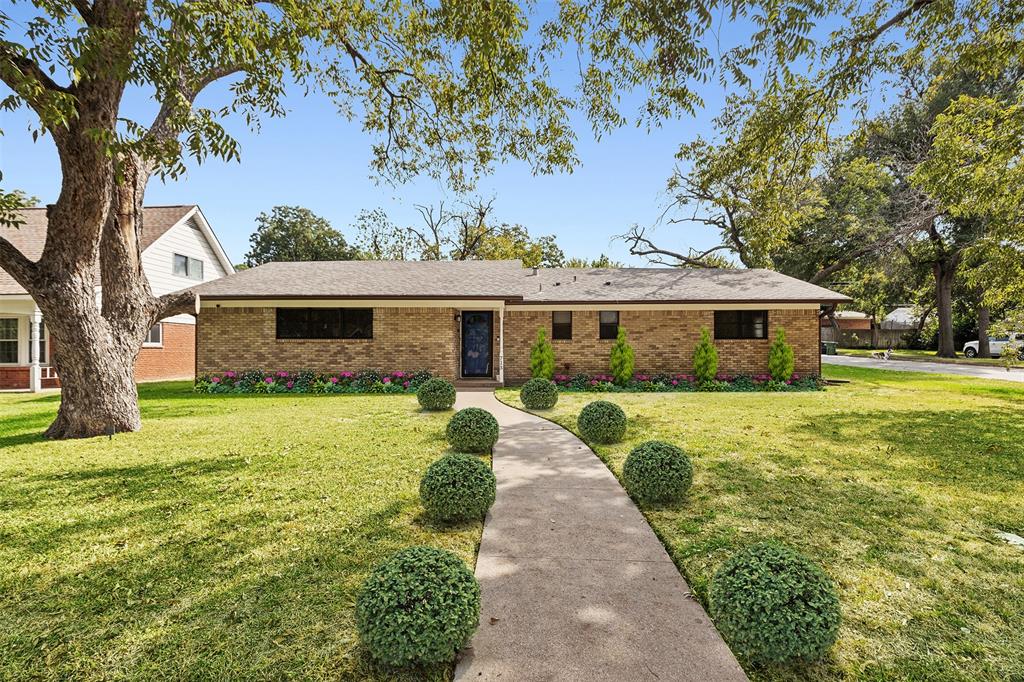 a front view of a house with a yard and trees