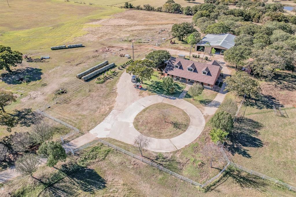 an aerial view of a house with a yard and lake view