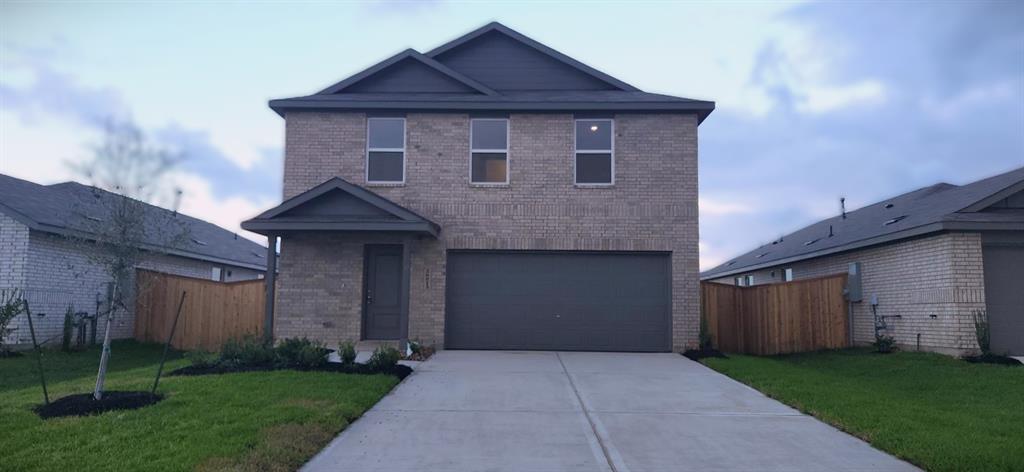 a view of a house with brick walls and a yard