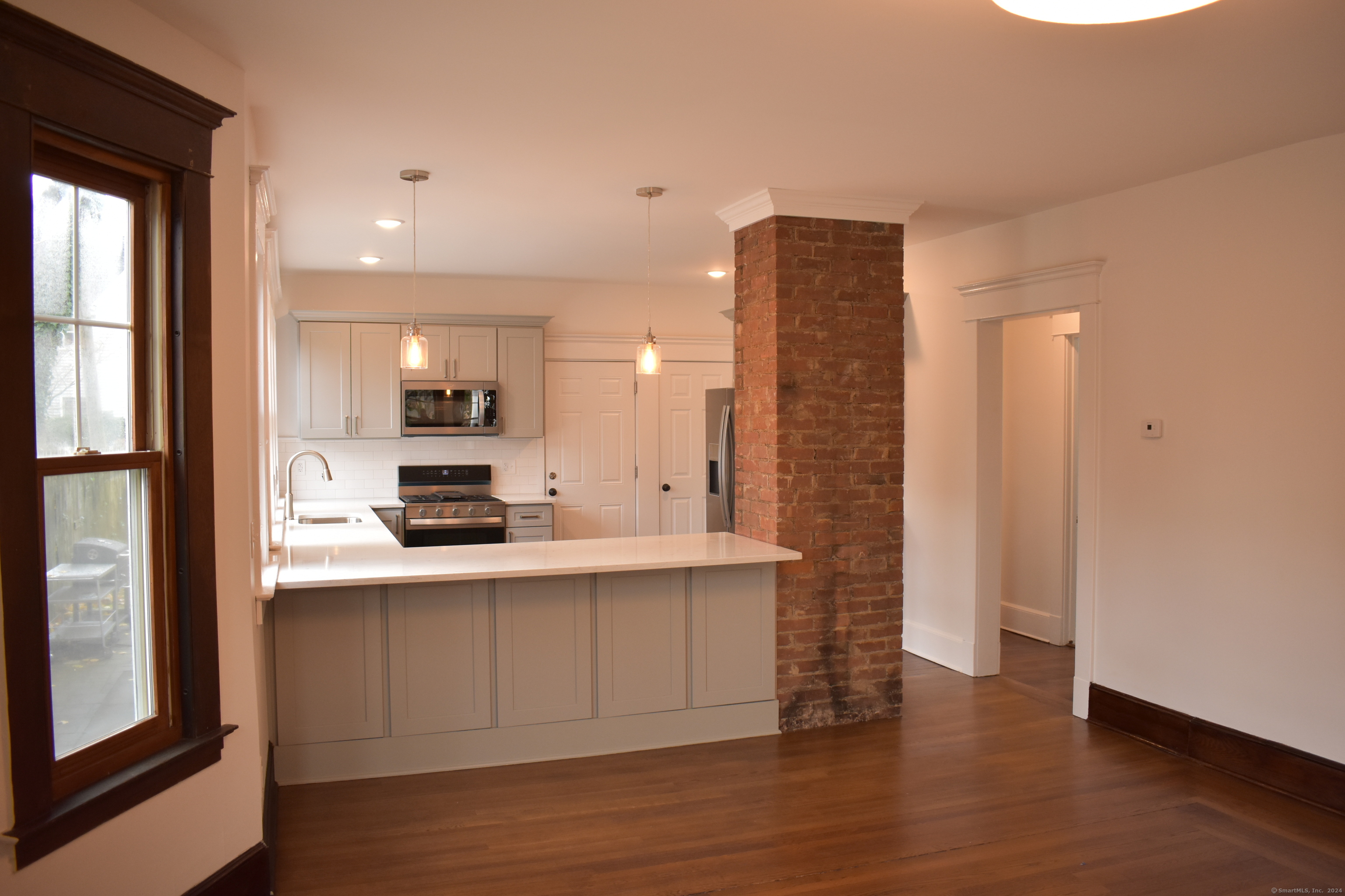 a view of kitchen with stainless steel appliances cabinets and wooden floor