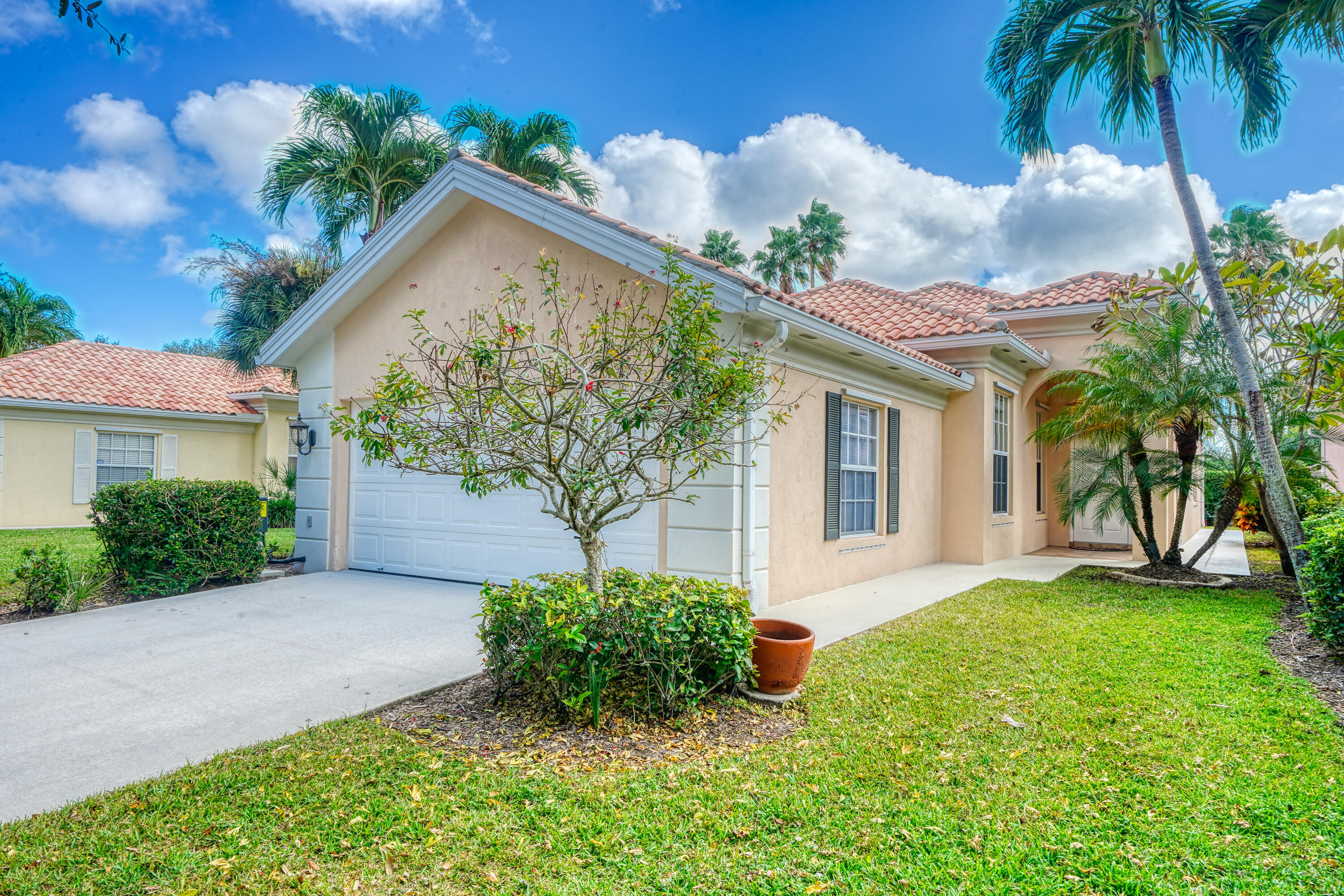 a front view of a house with a yard and potted plants