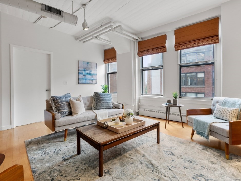 a living room with furniture a rug and a large window