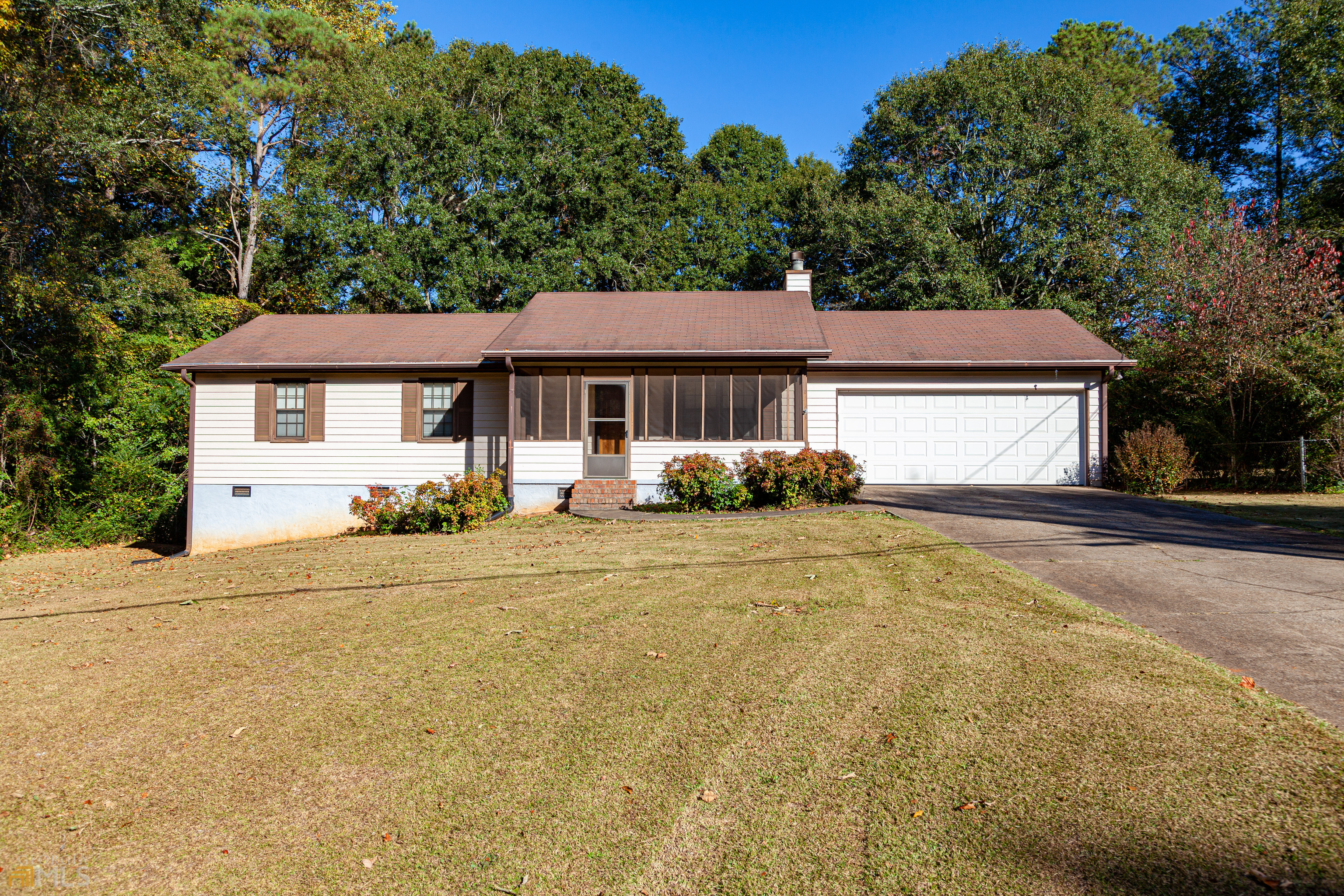 a front view of a house with a yard and trees