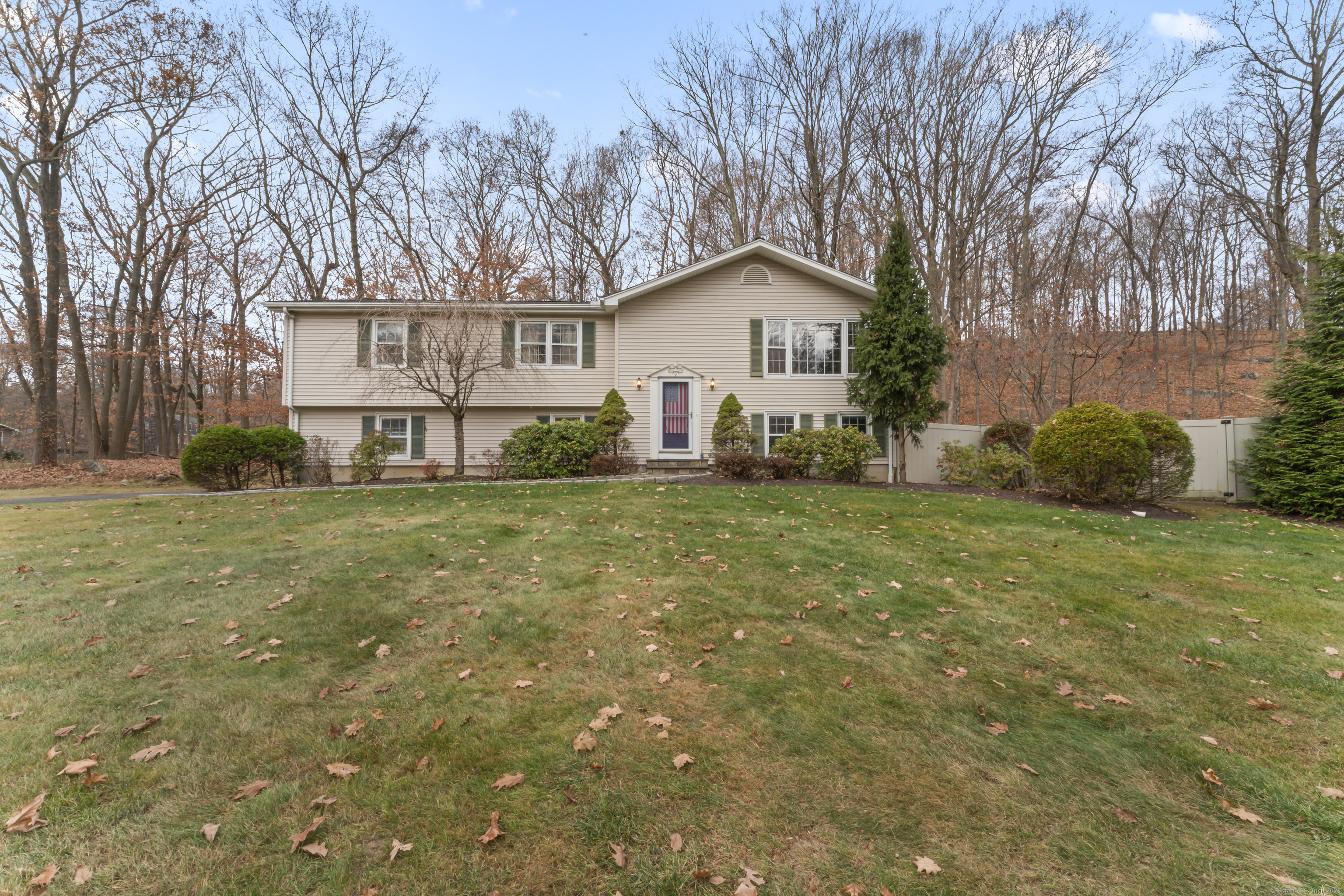 a front view of house with yard and trees all around