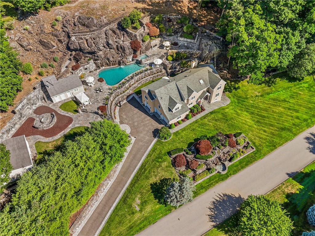 an aerial view of a house with a garden and lake view