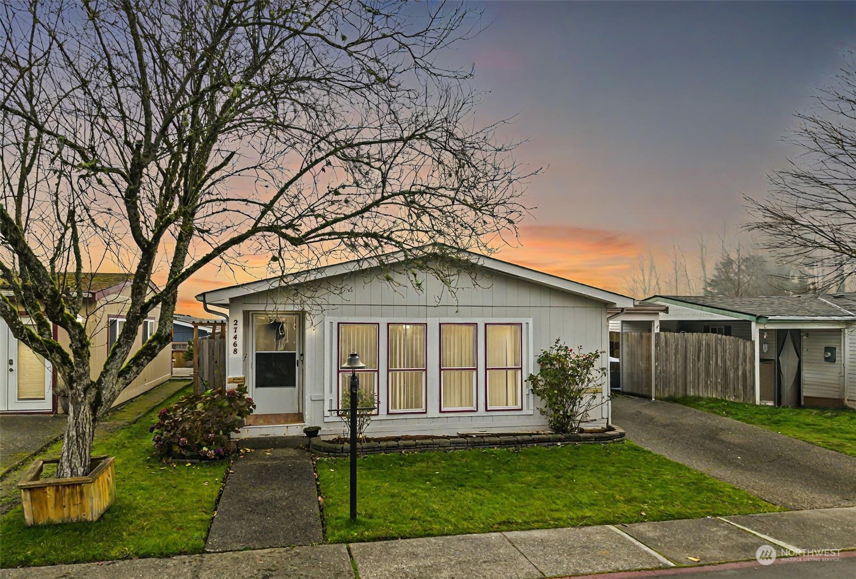 a front view of a house with a garden and yard