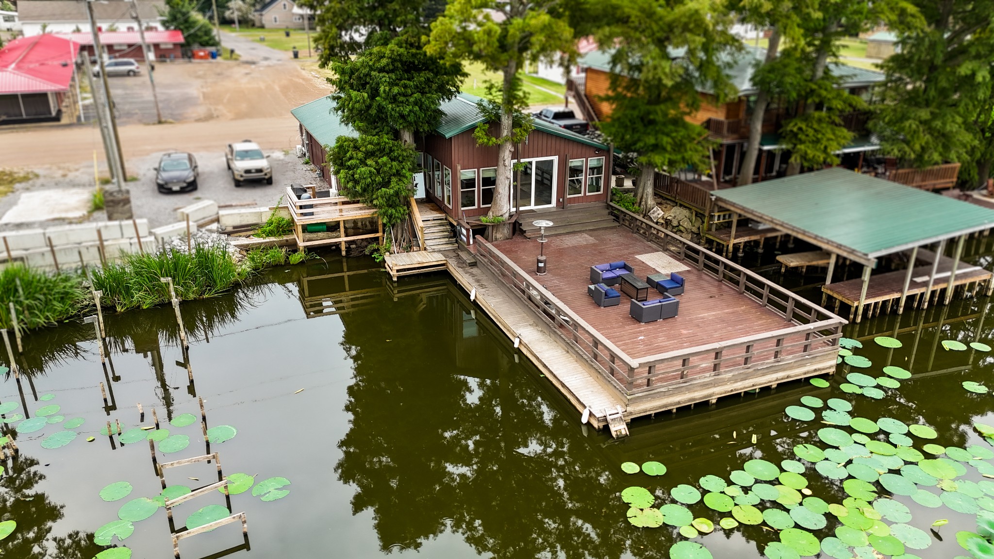 an aerial view of a house with swimming pool and large trees