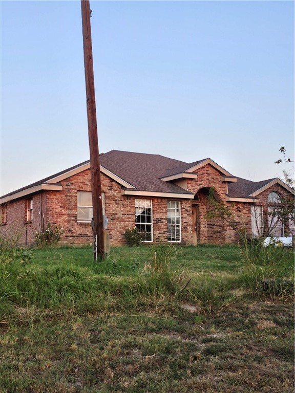 a view of a house with a yard and a tree