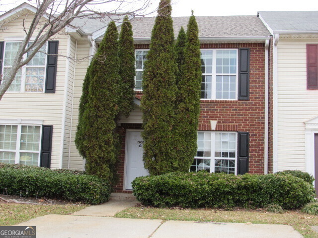 a view of a brick house many windows and plants