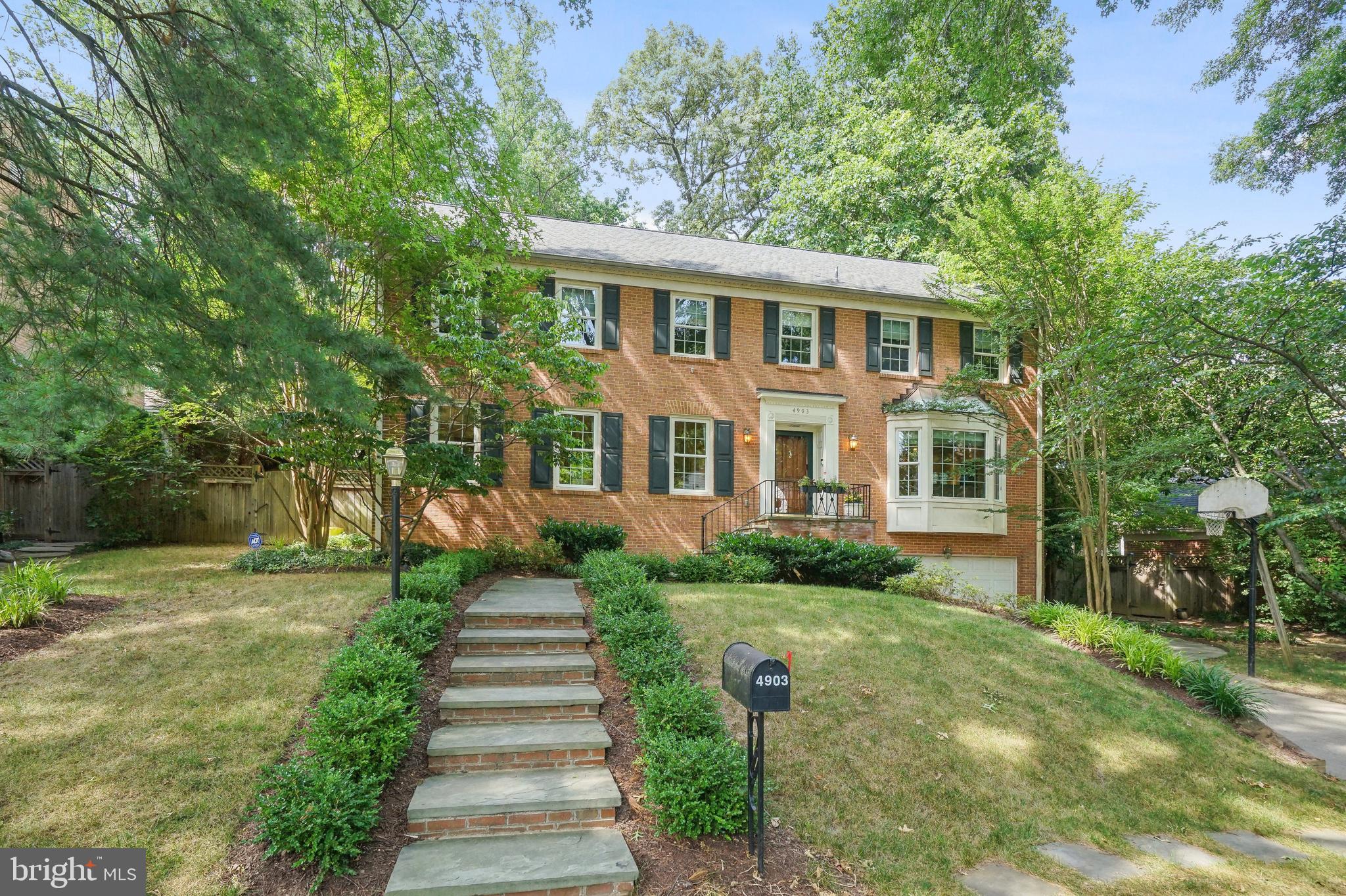 a front view of a house with a yard and trees