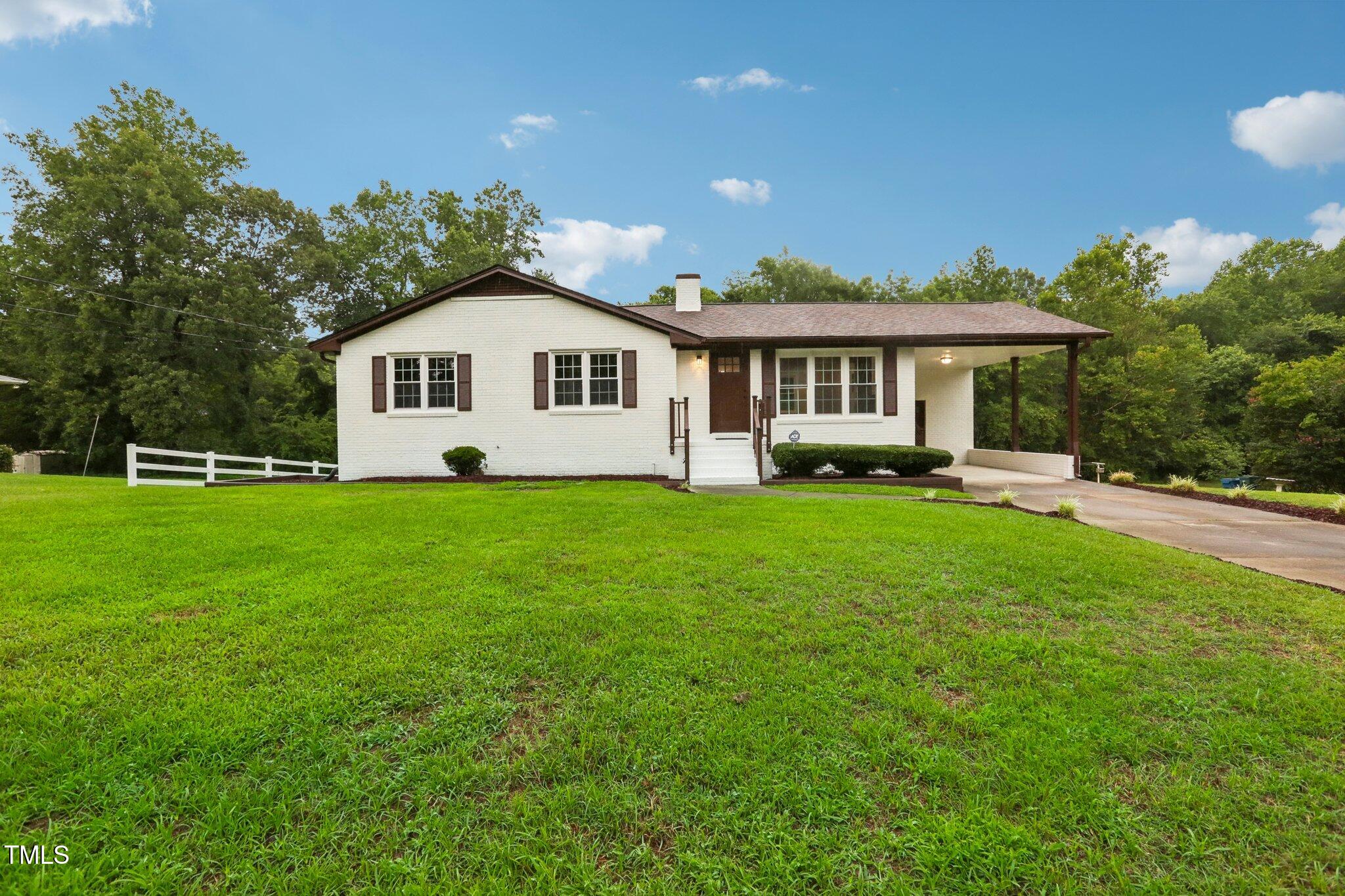 a front view of a house with a yard and trees