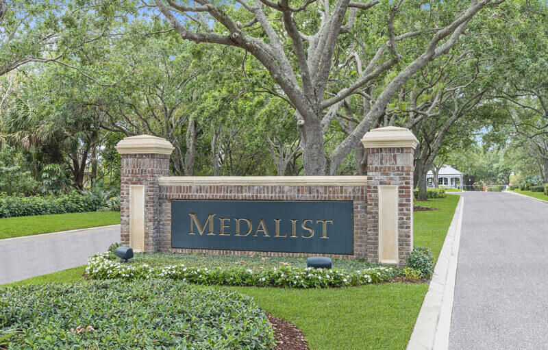 a sign board with a house and garden area