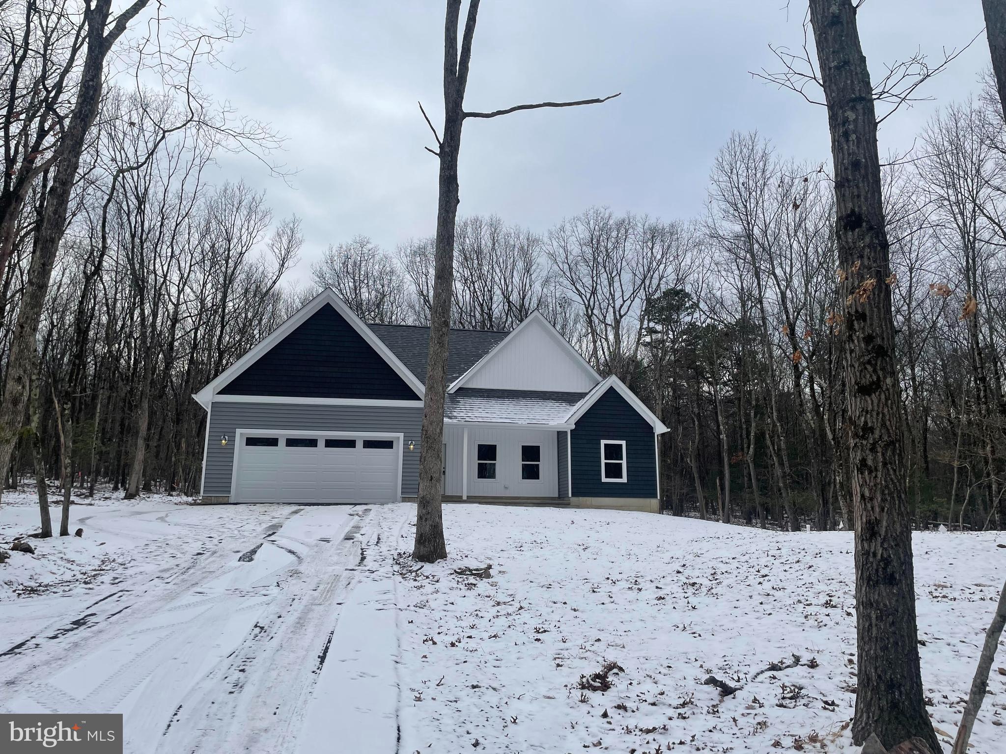 a front view of a house with a yard covered with snow