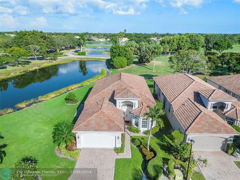 an aerial view of a house with a garden and lake view