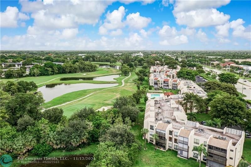 an aerial view of a city with lots of residential buildings green landscape and ocean view