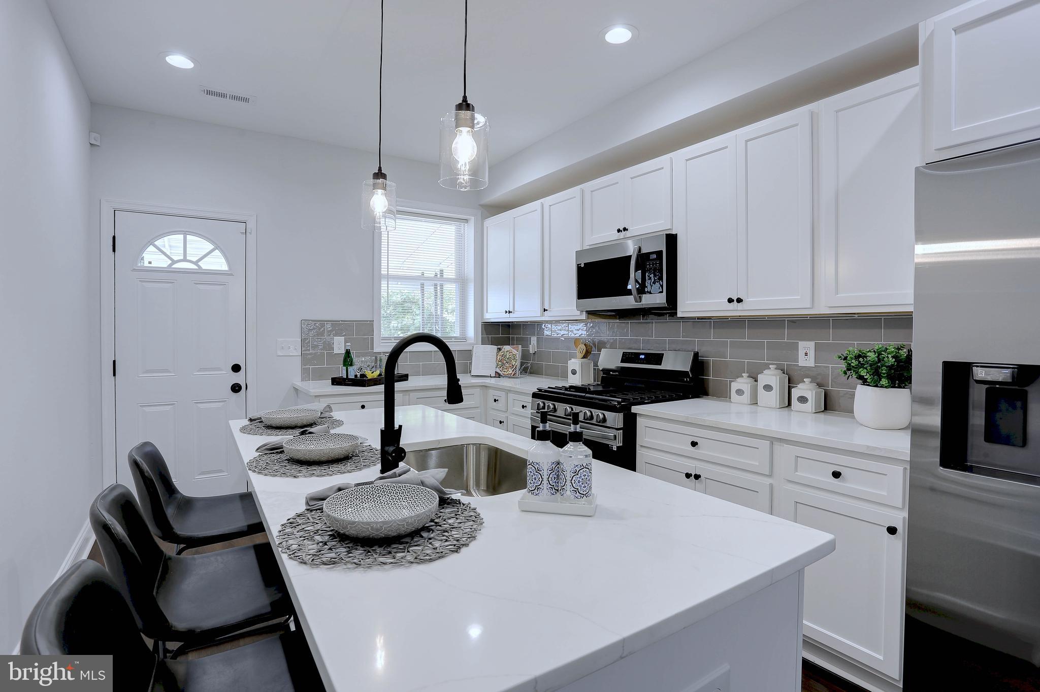 a kitchen with stainless steel appliances kitchen island granite countertop a sink and a stove