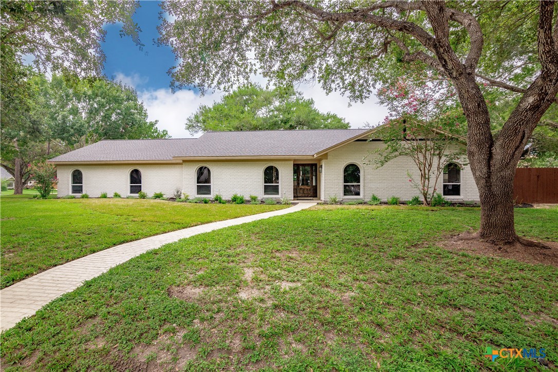 a front view of a house with yard and green space