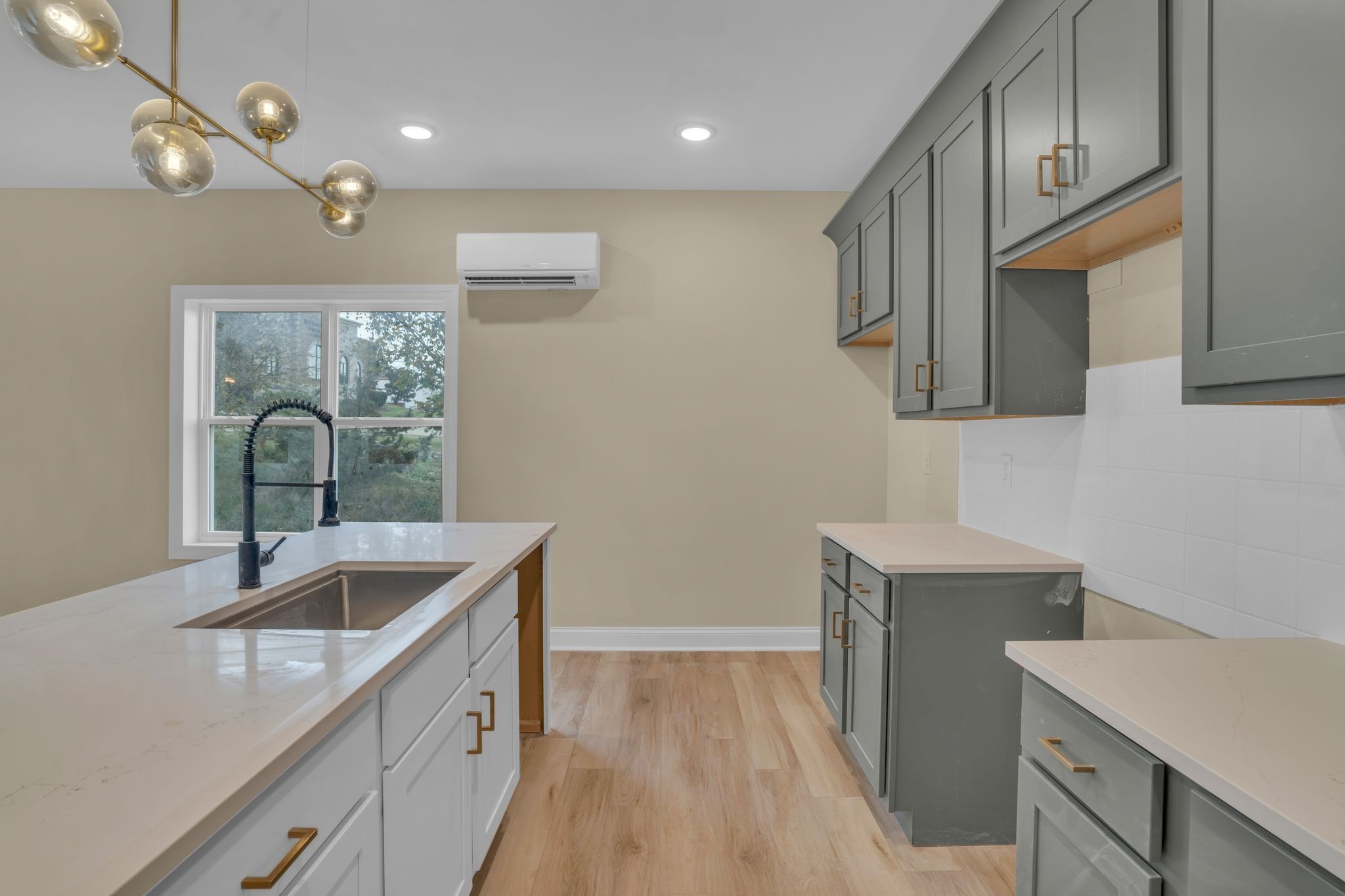 a kitchen with a sink cabinets and wooden floor