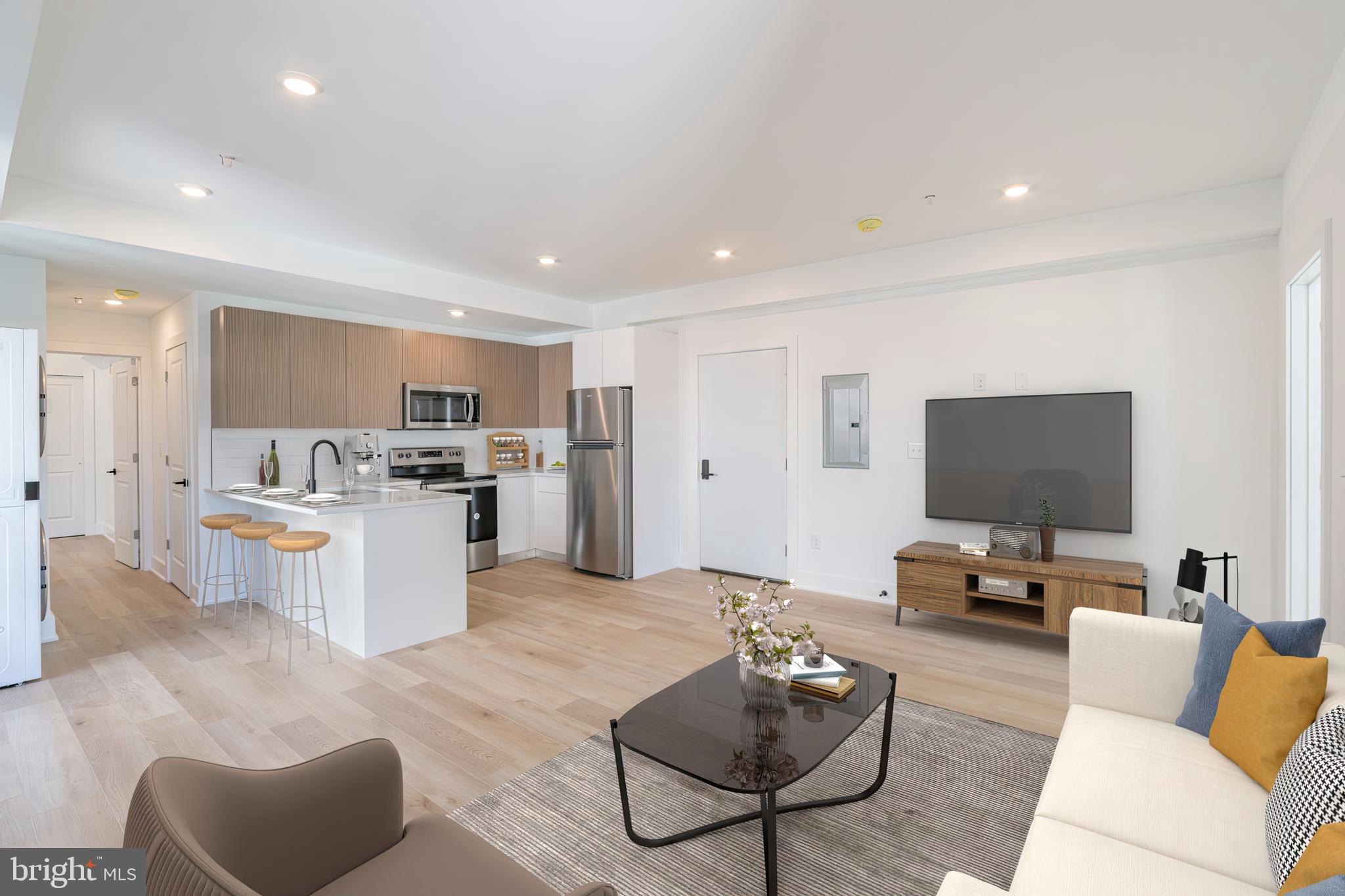 a living room with furniture kitchen view and a flat screen tv