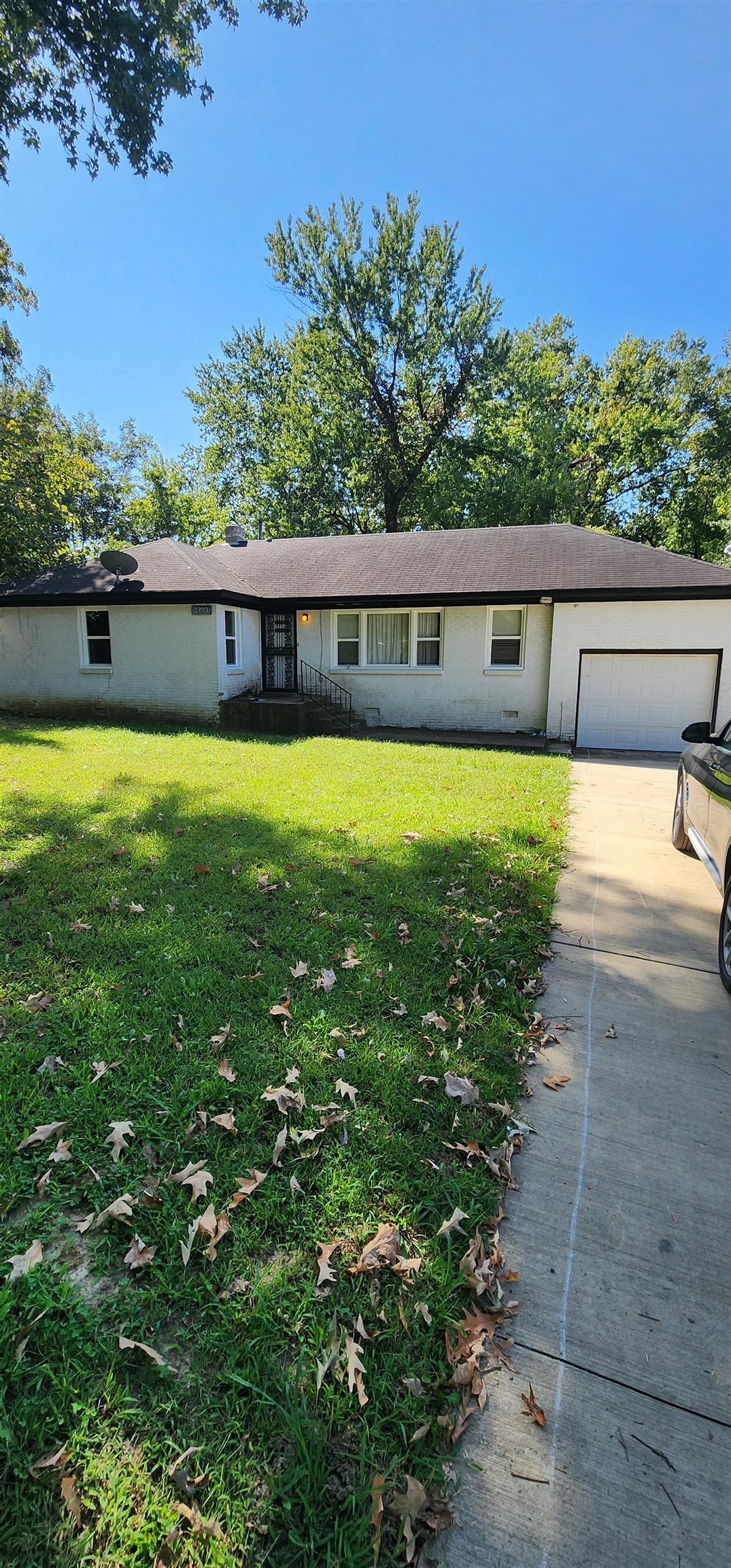 Single story home with a garage and a front lawn