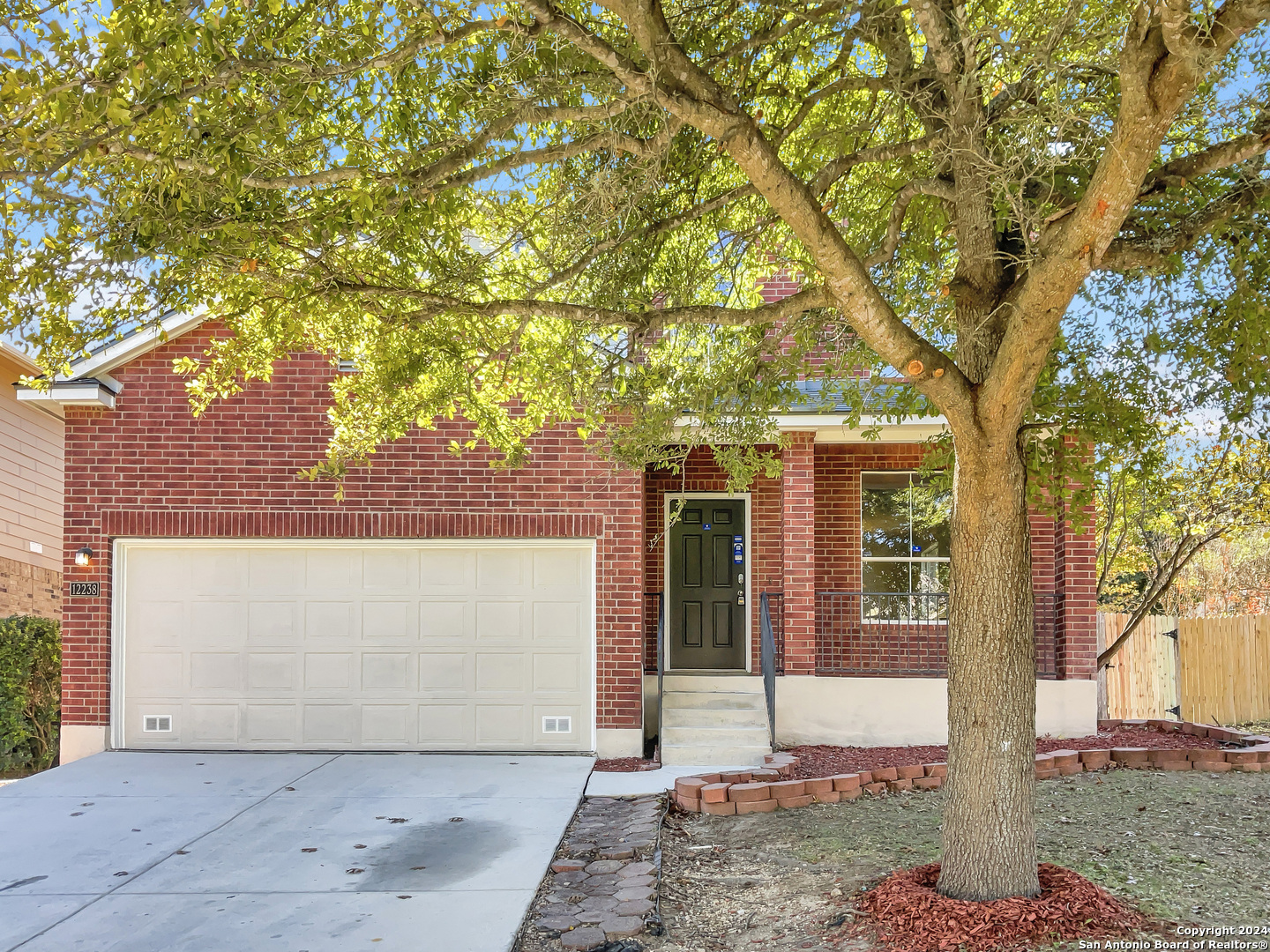 front view of a house with a tree