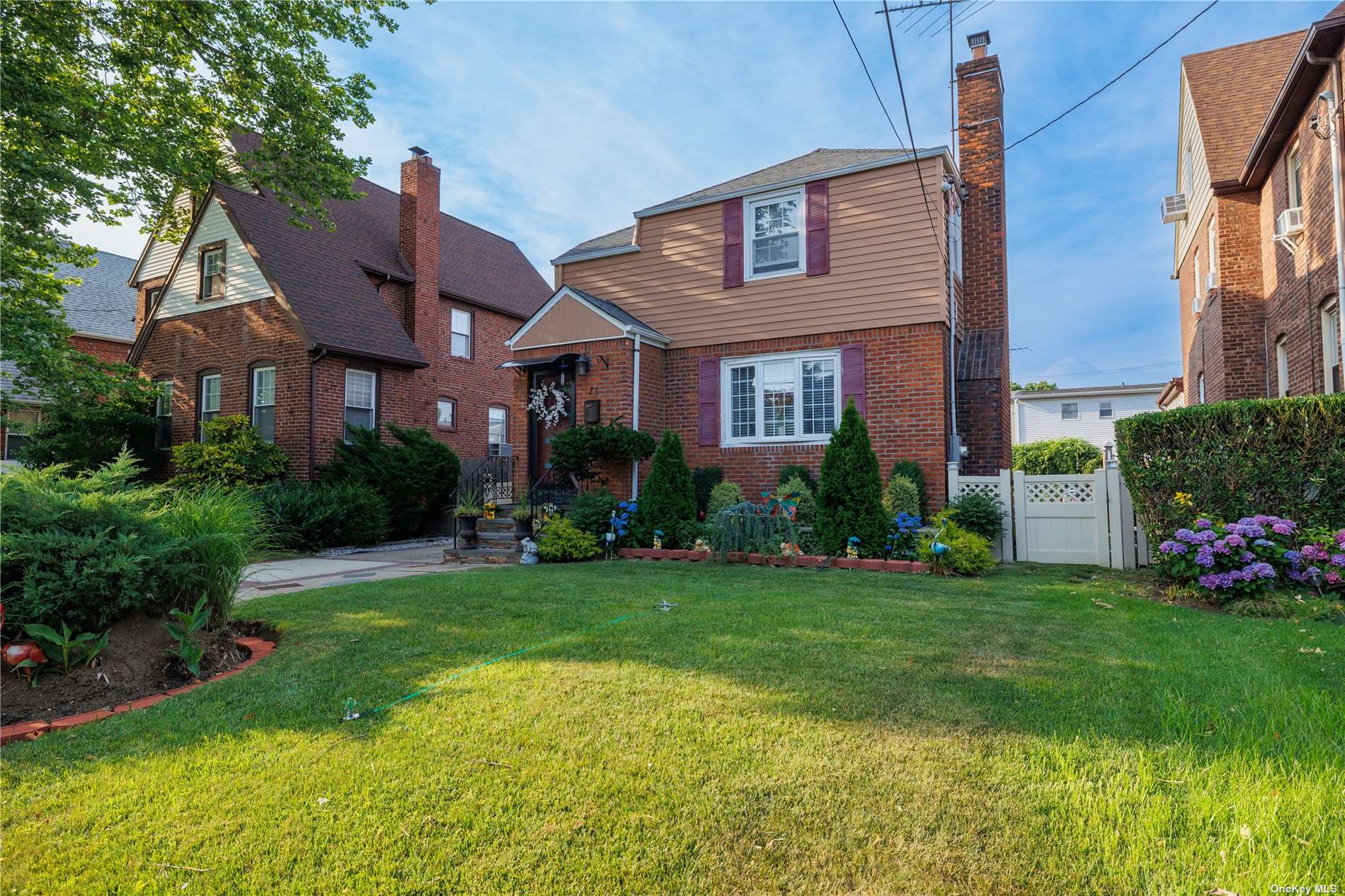 a front view of a house with a garden and plants