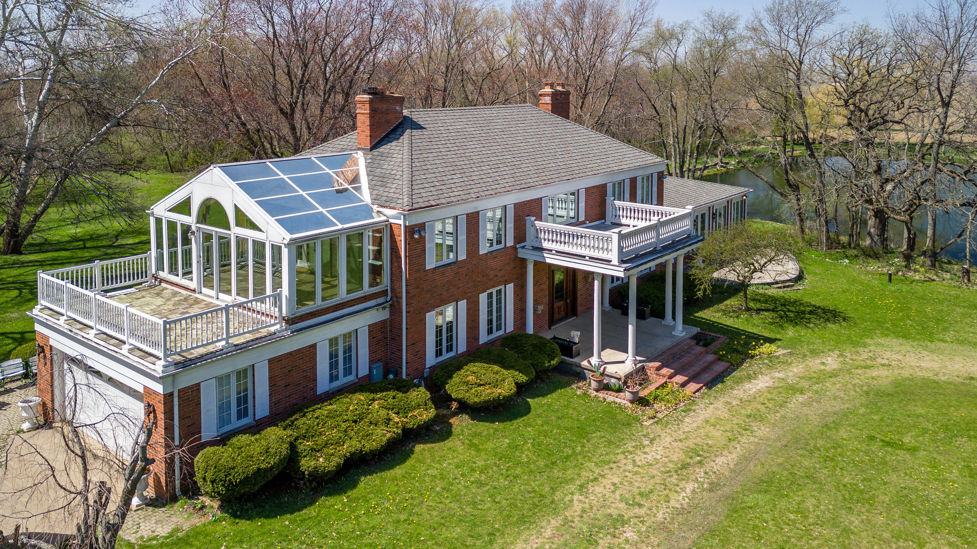 an aerial view of a house with swimming pool and garden