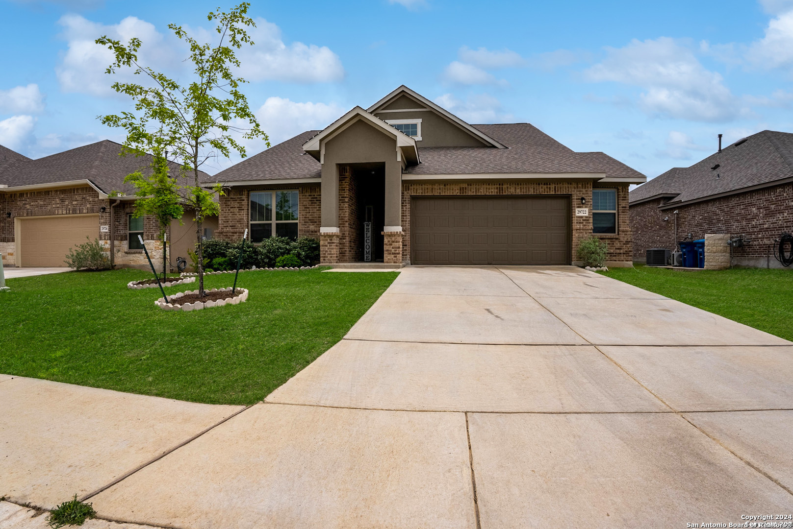 a front view of a house with a garden and trees