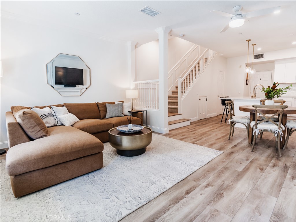 a living room with furniture a wooden floor and a flat screen tv