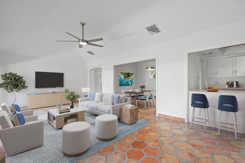 a living room with furniture kitchen view and a potted plant