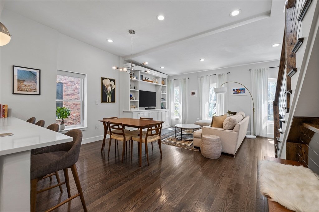 a living room with furniture flat screen tv and wooden floor