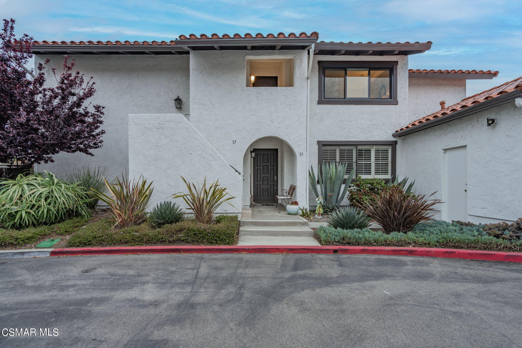 a front view of a house with a garden