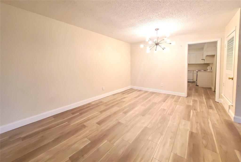 a view of a room with wooden floor and a ceiling fan