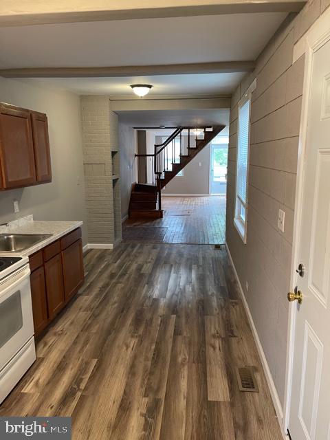 a view of entryway and kitchen with wooden floor