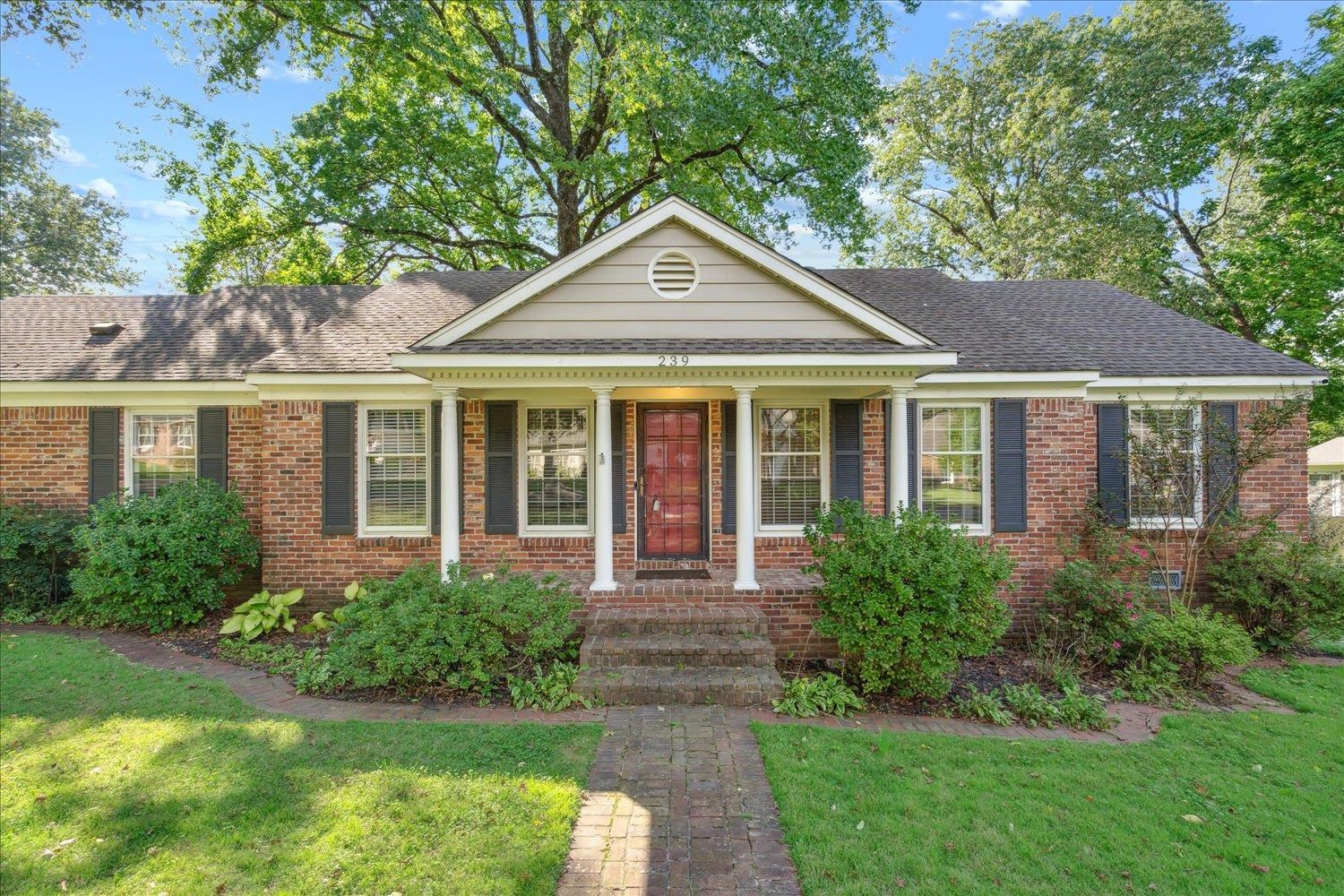 a front view of a house with yard and green space